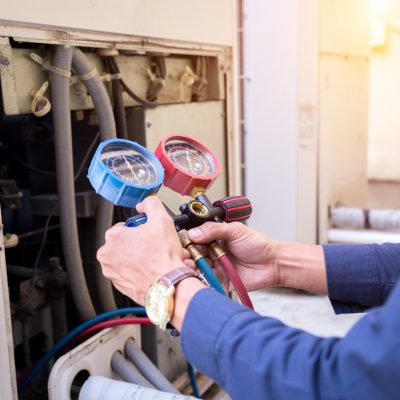 Technician is checking air conditioner ,measuring equipment for filling air conditioners.